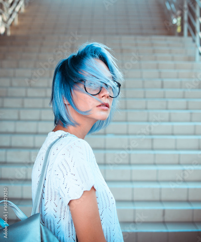 Φωτογραφία Close-up portrait of a hipster girl wearing glasses with blue hair