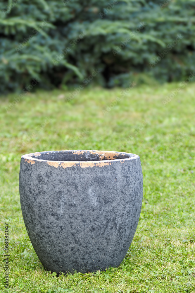 Empty grey flower pot in garden