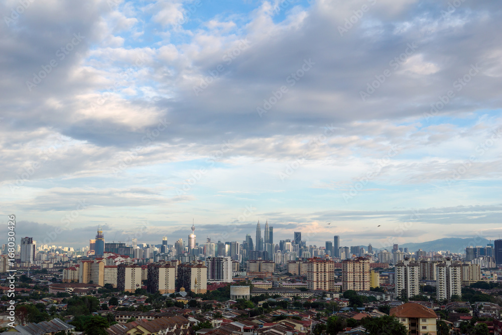 Landscape view of downtown Kuala Lumpur skyline, Malaysia under cloudy blue sky