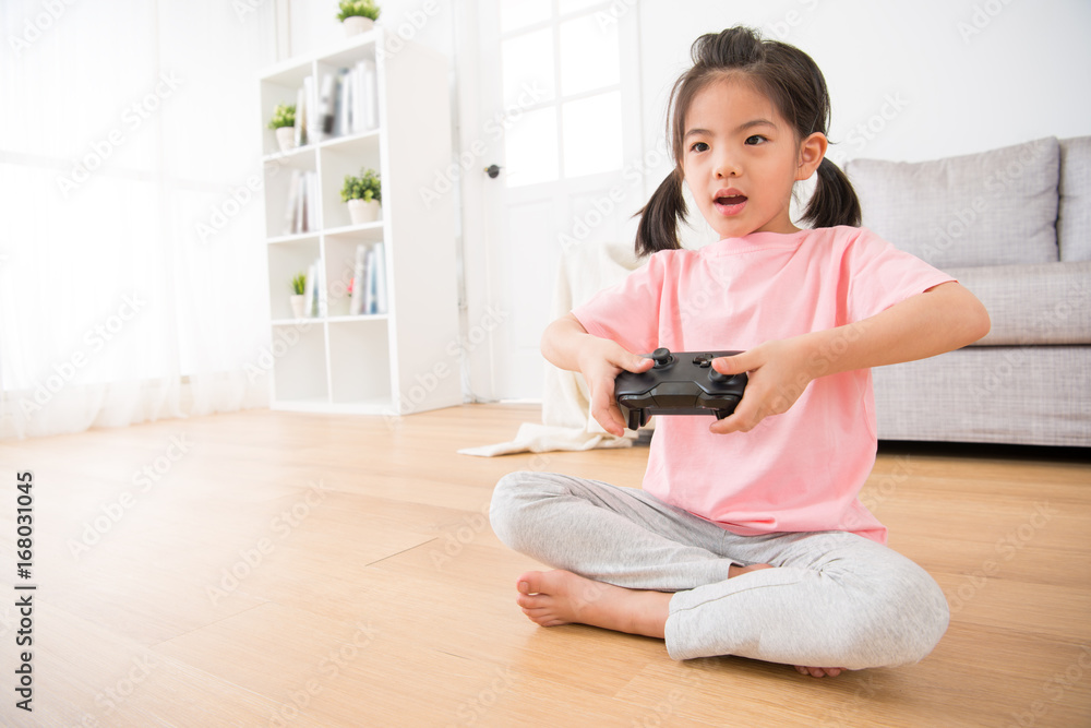 happy little daughter focus on using game joystick