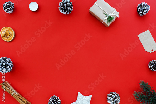 Christmas and New Year background - Christmas gift, pine cone and Xmas decoration on red background. Holiday concept. Creative flat lay, top view design