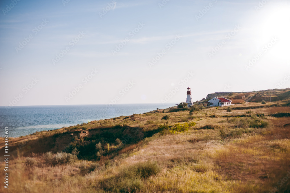 Lighthouse over the sea near the house