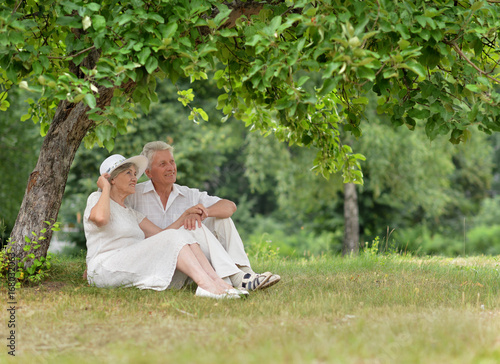 senior couple sitting on grass