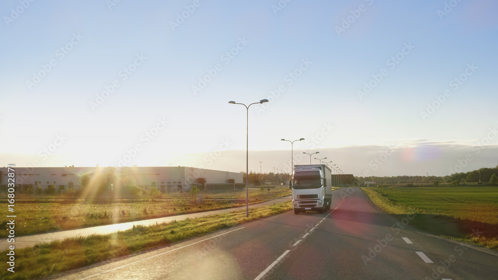 White Semi Truck with Cargo Trailer Drives on a Highway with Beautiful Sunny Scenery in the Background.