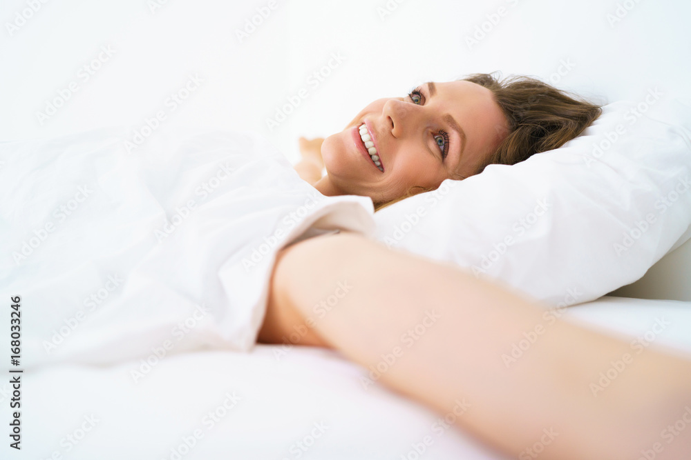 Cute girl sleeping in bed waking up stretching and smiling Cute girl sleeping in bed waking up stretching and smiling