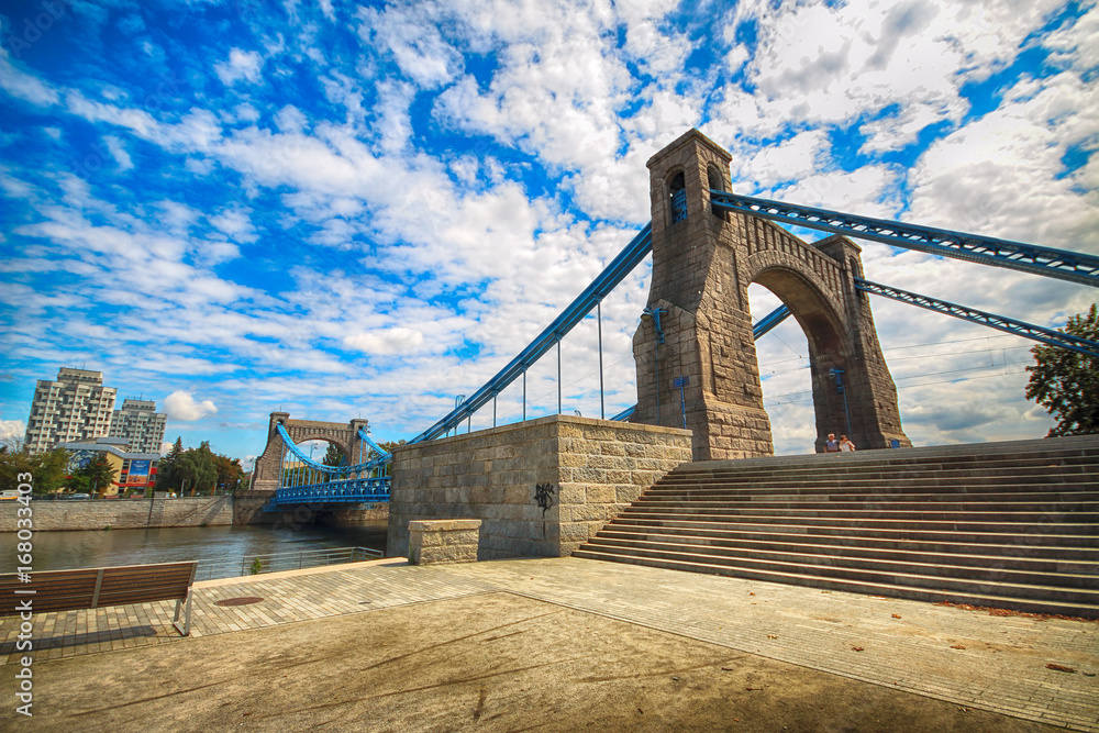 Obraz premium WROCLAW, POLAND - AUGUST 14, 2017: Grunwald Bridge (Most Grunwaldzki) is a suspension bridge over the river Oder in Wroclaw, built between 1908 - 1910. Designed by Richard Pluddemann.