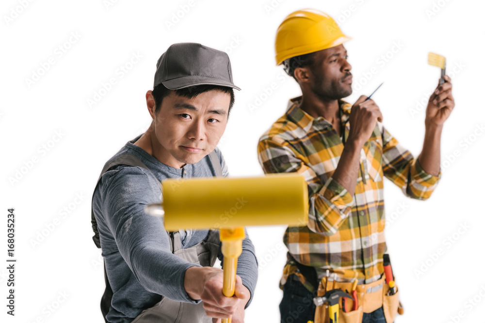 african-american and asian construction workers with tools african-american and asian construction workers with tools