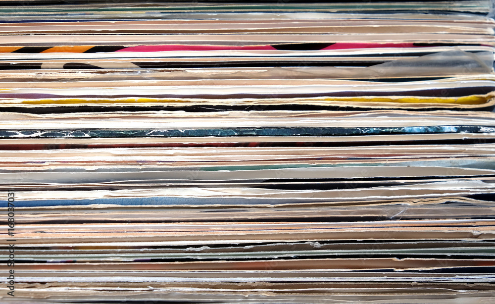 Horizontal pile of many close standing vinyl records covers as background front view close up Horizontal pile of many close standing vinyl records covers as background front view close up