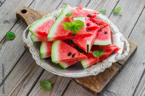 Fresh sliced watermelon in a metal bowl wooden background