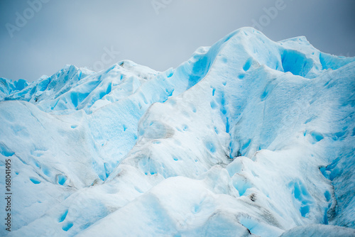 The blue glacier rises and shines in the daylight. Shevelev.