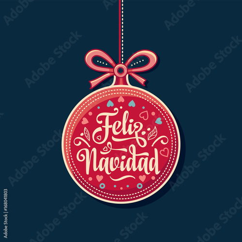Feliz Navidad.  Red Christmas ball with good wishes in Spanish. 