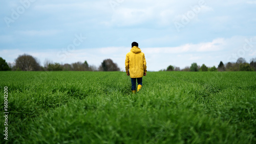 man in yellow raincoat in field