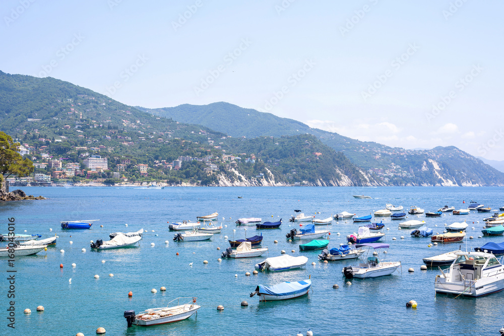 Daylight view to boats on blue water near Rapallo city in Italy.