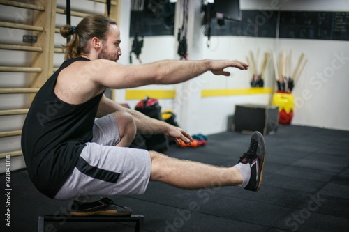 Man working out in a gym. Young woman stretching in gym.