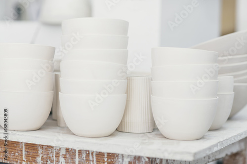 Unglazed white ceramic bowls in a studio