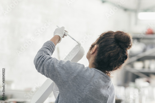 Ceramic artist in her studio painting a hand made bowl