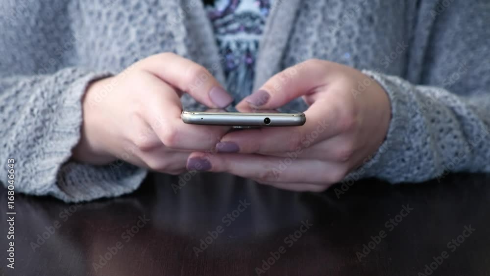 Female Hands Closeup Use a Smartphone, Thumbing Through the Information on the Touch Screen. the Phone Screen Reflects the Sunlight Female Hands Closeup Use a Smartphone, Thumbing Through the Information on the Touch Screen. the Phone Screen Reflects the Sunlight