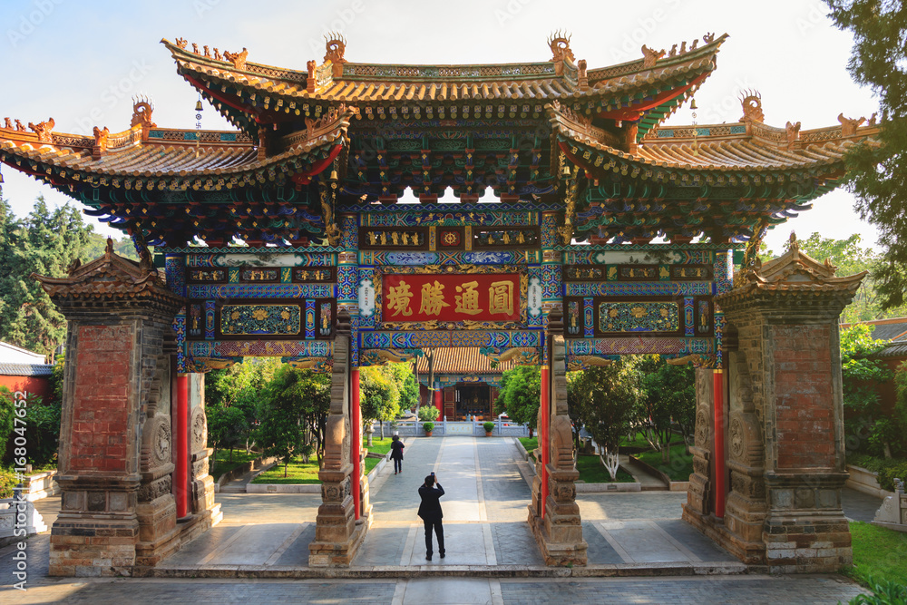 Huge oriental stone gate leading to Chinese Buddhist temple