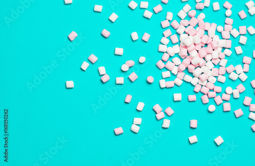 Pink and white Marshmallows on blue background. Top view, flat lay. free space for your text