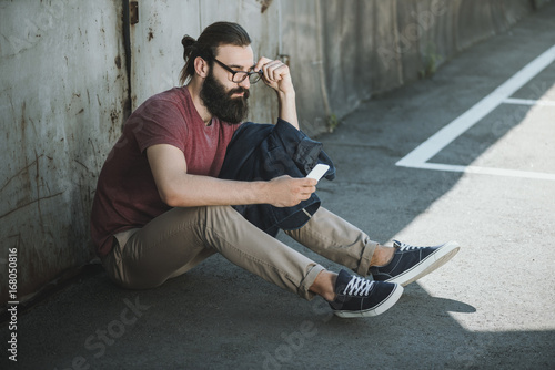 man sitting on floor and using phone