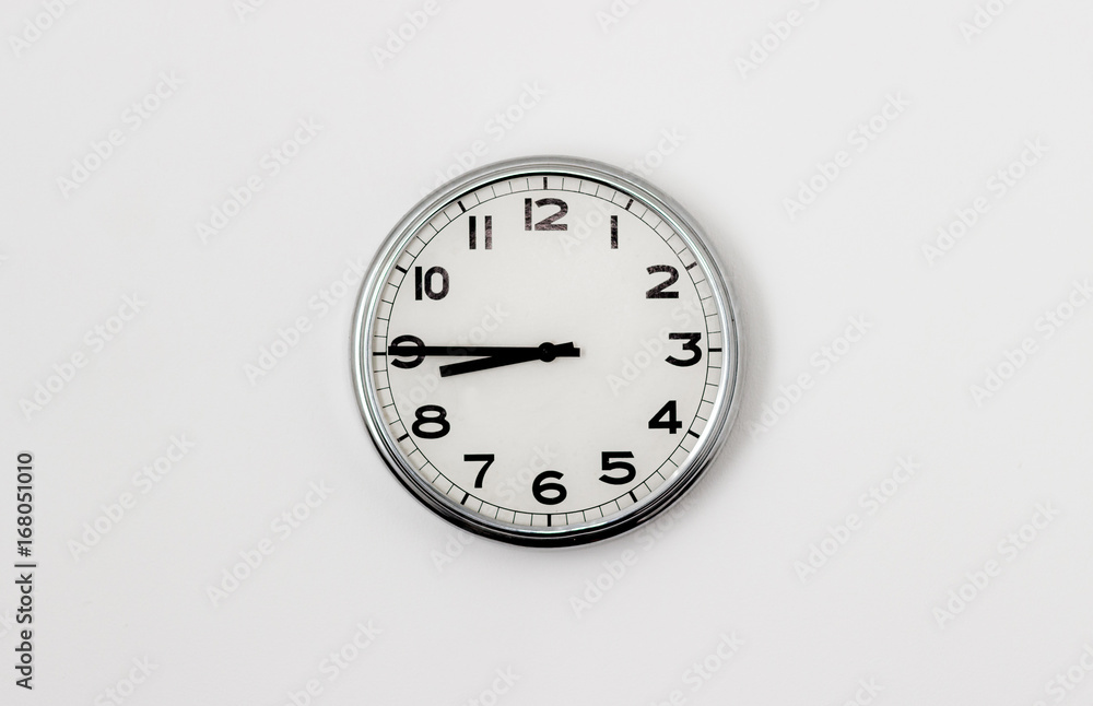 White Clock hanging on a white wall showing time 8:45 Stock Photo | Adobe  Stock