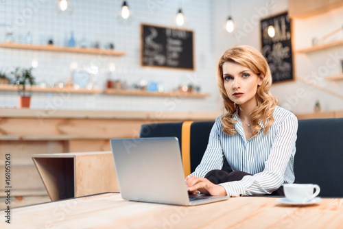 businesswoman using laptop in cafe