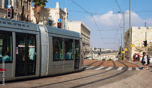 Modern tram goes along the street of Jerusalem.