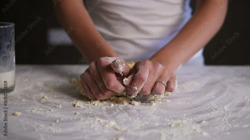 Woman kneading dough in flour on the table. Baker prepares the dough. Hands kneadining dough. Slow motion shot Woman kneading dough in flour on the table. Baker prepares the dough. Hands kneadining dough. Slow motion shot
