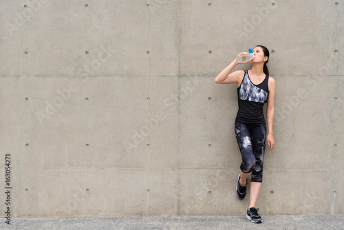 Fototapeta Naklejka Na Ścianę i Meble -  exercise woman drinking water after jogging