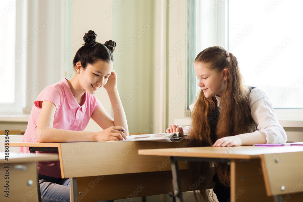 Schoolgirls do the job,Girls look in the textbook and discuss the job Schoolgirls do the job,Girls look in the textbook and discuss the job