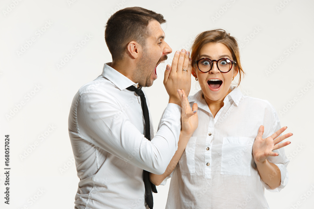 The business man and woman communicating on a gray background The business man and woman communicating on a gray background