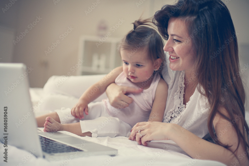 Mother and her little baby at home. Mother with her baby watching something on digital tablet. Mother and her little baby at home. Mother with her baby watching something on digital tablet.