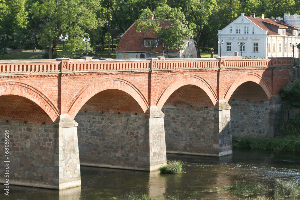 Classic, historic brick bridge over small river.