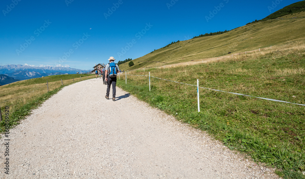 traveler walking on a trail in Dolomites Mountains, South Tyrolo, Italy