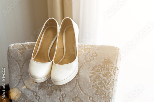 Wedding shoes on the back of the armchair near the window