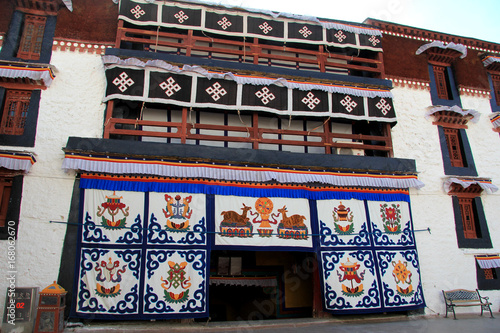 the part of the Potala Palace, with the people republic of China flag inside as well as many windows, curtain, Brick wall, Potala Palace square, Tibet Admiralty, golden chimes and Colored prayer

