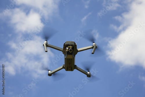 The drone flying over the blue sky background to take a photo / The flying drone on the sky © Igorzvencom