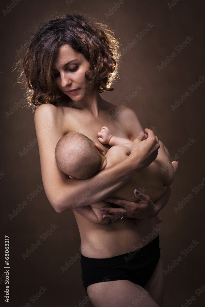 Obraz premium Young mother holding a baby in her arms