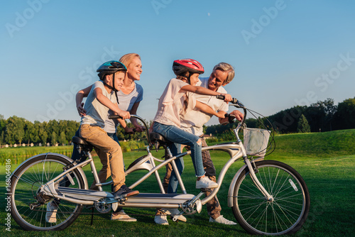 grandparents helping children ride bicycle