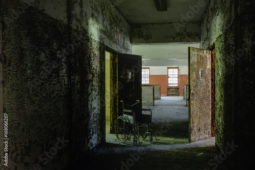 Hallway with Vintage Wheelchair & Open Doors - Abandoned Hospital © Sherman Cahal