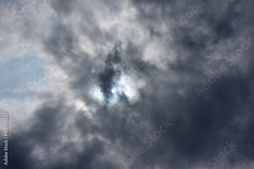 雲に隠された太陽と青空「空想・雲のモンスター〔翼を広げたプテラノドン、翼竜（太陽が目）などが出現し始めたイメージなど〕」何かが存在する気配、蠢く、秘密の力などのイメージ