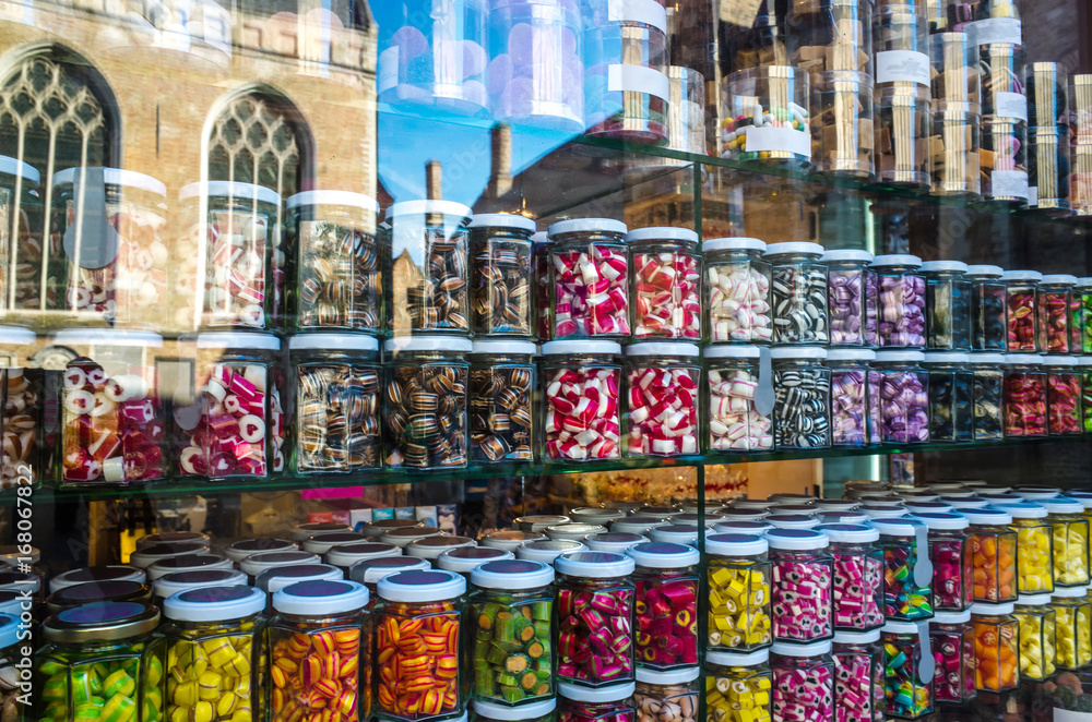 Showcase with colored caramel in jars