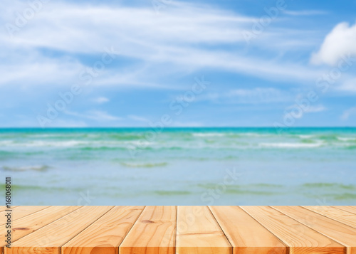 Wooden table in front of abstract blurred sea & coconut tree background. For present your products. Summer Concept