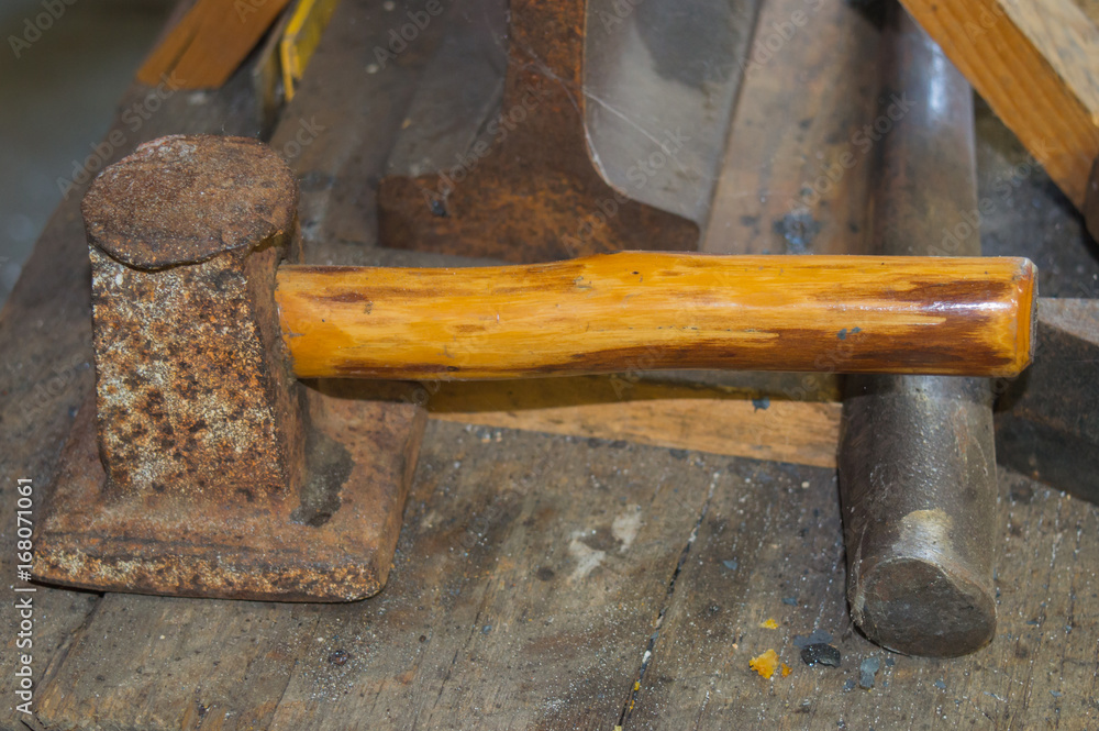 A rusty flatter that is to be struck by a sledgehammer is found in the blacksmith shop. A rusty flatter that is to be struck by a sledgehammer is found in the blacksmith shop.