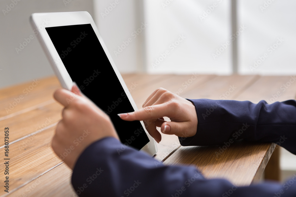 Female using digital tablet, close up, side view,
