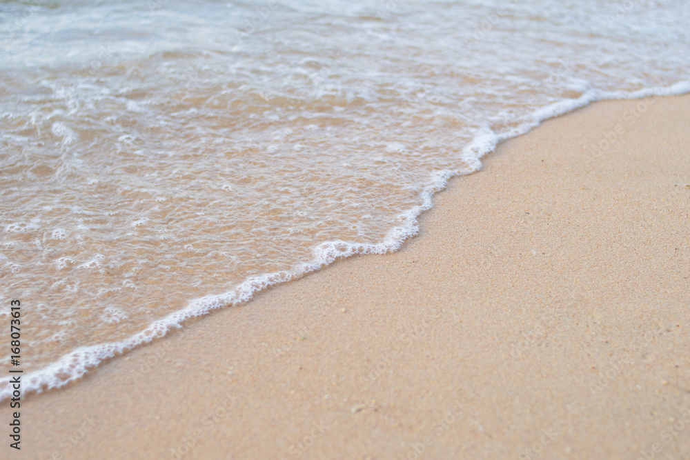 sea water waves with bubbles on sand beach