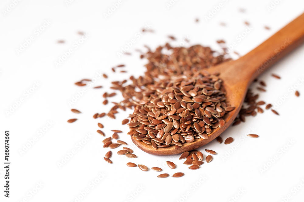 Flax seeds and spoon on white background Flax seeds and spoon on white background