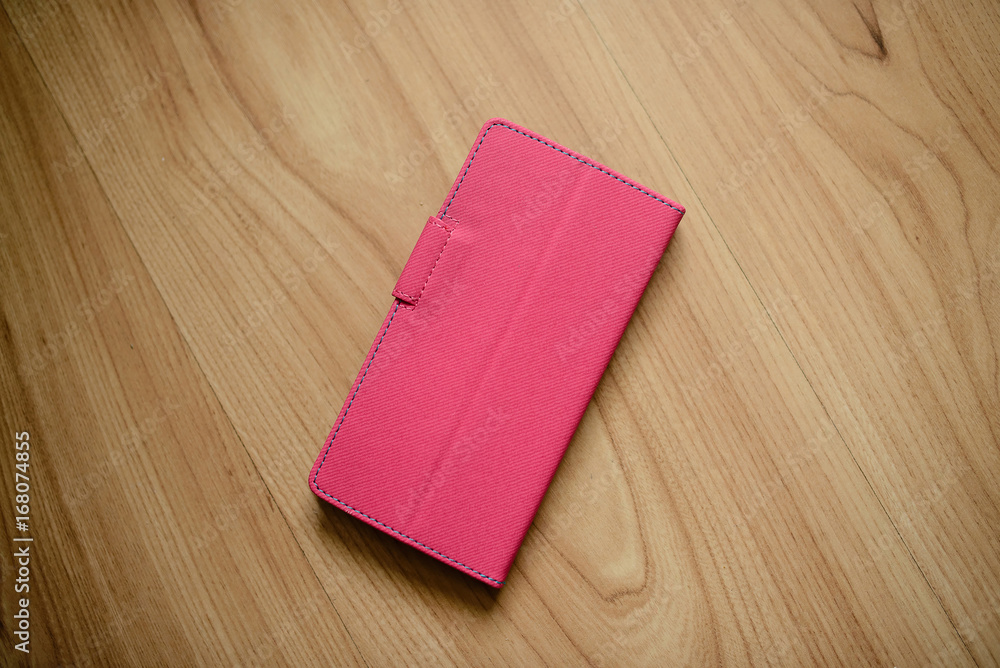 Pink leather case for mobile phone-on a wooden surface. Pink leather case for mobile phone-on a wooden surface.