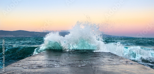 Sea waves in sunset with rocks and stones. Nature landscape.