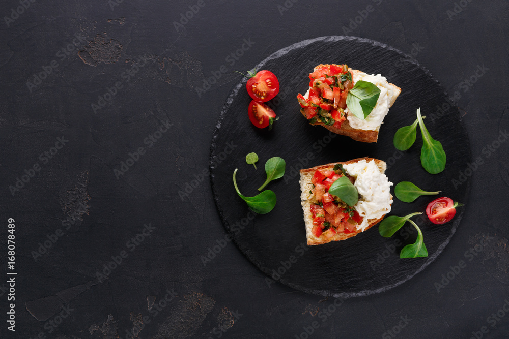 Bruschetta with cheese and vegetables on black background